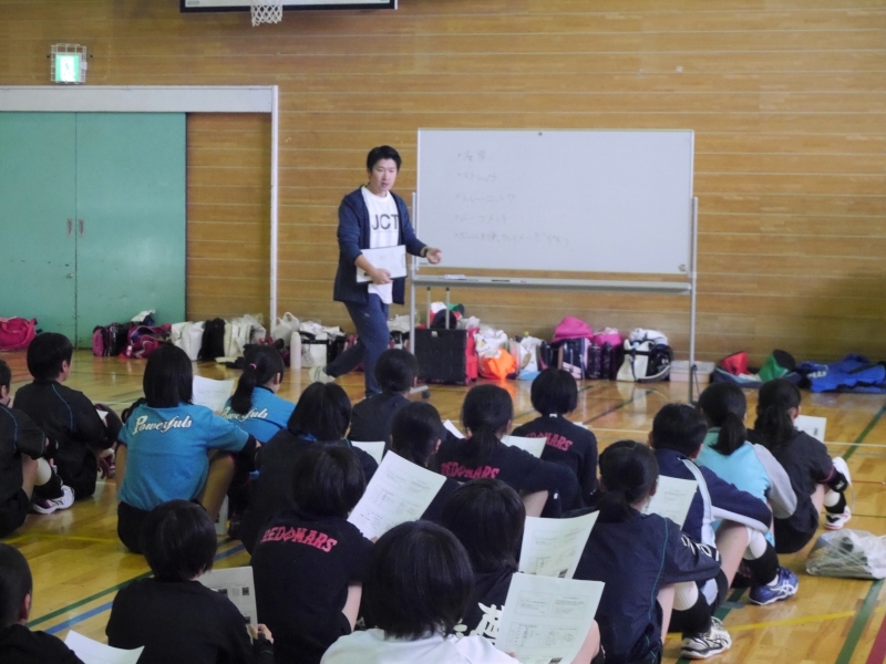 スポーツ現場で選手に身体の使い方や動きの改善ポイントを説明している様子